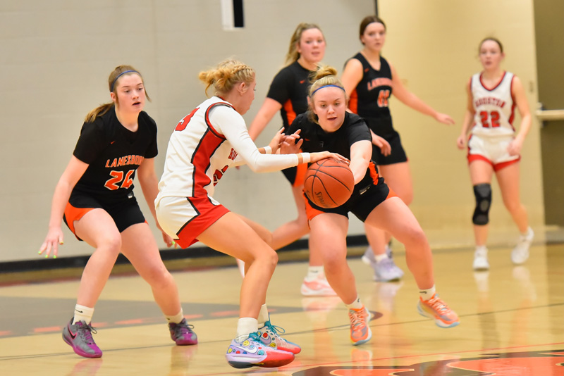 Lanesboro’s Jensyn Storhoff goes for the steal on Houston’s Aubry Boldt in the teams’ SEC battle. Cora Mayer is also pictured. Hurricane Olivia Yohe hit a three with 11.7 seconds left that proved the game-winner in a 46-45 Houston win. Photo by Ron Mayer