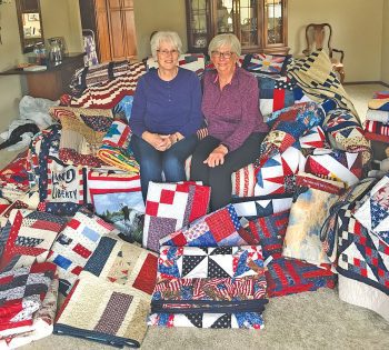 Ladies sit on couch with quilts