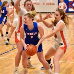 Bailey Erwin and Hailey Erickson go after Nelson in Girls Basketball.