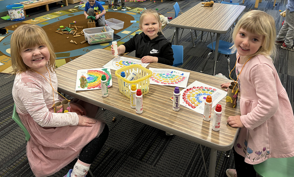 Preschool girls learning about the letter Rr making rainbows with paint dobbers. Photo submitted
