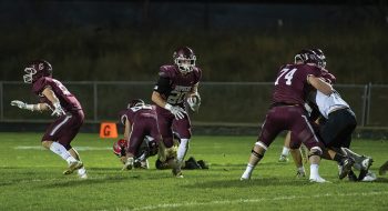 Chatfield’s Ben Carrier runs through a gaping void as lineman Mitchel Hinckley (background) and Jake Stevens (right) dominate blocks while Ethan Eickhoff (left) is also shown. Carrier ran for 208 yards and three scores as the #2 Gophers pounded #8 Cannon Falls 40-8 to clinch their third Southeast-White title in four years. Photo by Leif Erickson