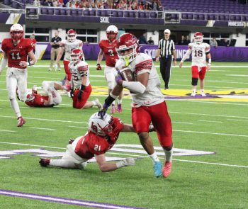 Fertile-Beltrami’s Isaiah Wright breaks the tackle attempt of LeRoy-Ostrander/Lyle/Pacelli’s Tyson Stevens and makes his way for one of seven rushing touchdowns in a state semifinal. The Cardinals led 33-30 later in the third quarter, but Wright ran for 363 yards, as the Falcons won the game 60-33. Photo by Paul Trende