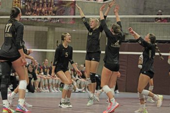 Caledonia’s Aubrie Klug (#5), Sienna Augedahl (facing), and others celebrate the latter’s block in the Warriors’ 3-2 1AA quarterfinal win over Pine Island. Caledonia fell in the semifinals to Z-M 3-1 to finish the year 21-10.