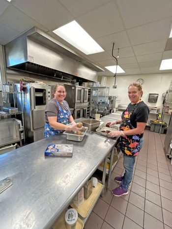 On the left, head cook Tracie Peterson and assistant, Joan VanGundy relax in their kitchen after cooking the day’s meals. Photo by Wanda Hanson