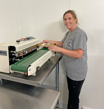 Lori is in charge of the bag sealing machine. Photo by Wanda Hanson
