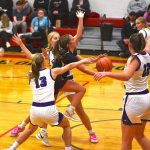 Spring Grove point guard Siri Konkel slices through the Grand Meadow defense to score with an underhanded scoop shot. Defending for the Superlarks are (#13) Alyssa Peterson, Aspen Kolling and (#22) Rylee Schaufler. Konkel scored seven points and passed out a game-high seven assists as the Lions turned away the Superlarks in an early Southeast Conference showdown. Photo by Lee Epps