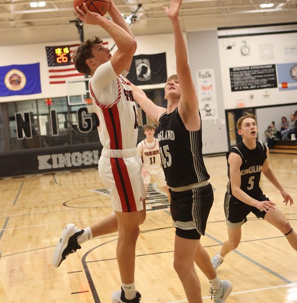 Spring Grove’s Zach Brumm attacks from the block over Kingsland’s Max Erdman in the teams’ SEC match-up in Spring Valley. A super close game saw the Lions pull away late for a 65-50 victory.