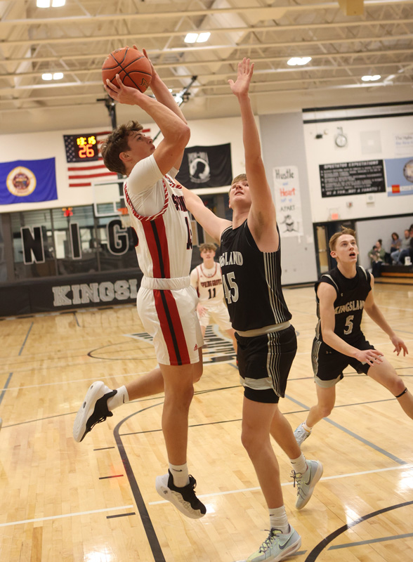 Spring Grove’s Zach Brumm attacks from the block over Kingsland’s Max Erdman in the teams’ SEC match-up in Spring Valley. A super close game saw the Lions pull away late for a 65-50 victory.