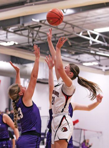 Spring Grove’s Kylie Hammel shoots over Grand Meadow’s Naomi Warmka in the teams’ SEC game for first place. The Lions ended on a 24-5 run to erase a 44-35 deficit and post a 59-49 win, grabbing sole possession of the top spot in the league. Photo by Paul Trende