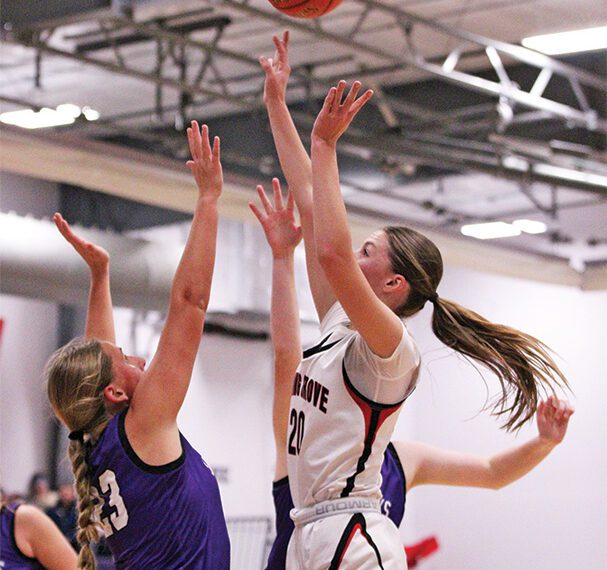Spring Grove’s Kylie Hammel shoots over Grand Meadow’s Naomi Warmka in the teams’ SEC game for first place. The Lions ended on a 24-5 run to erase a 44-35 deficit and post a 59-49 win, grabbing sole possession of the top spot in the league. Photo by Paul Trende