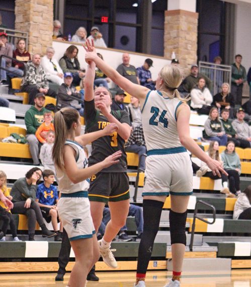 Rushford-Peterson’s Emily Helgemoe sends up the floater most notably over Fillmore Central’s Sophia Bronner (#24) at the Trojans’ holiday tourney. R-P beat the Falcons 58-34 to sweep the season series. Photo by Paul Trende