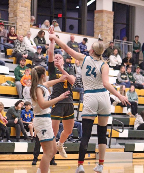 Rushford-Peterson’s Emily Helgemoe sends up the floater most notably over Fillmore Central’s Sophia Bronner (#24) at the Trojans’ holiday tourney. R-P beat the Falcons 58-34 to sweep the season series. Photo by Paul Trende