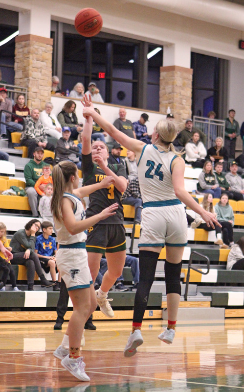 Rushford-Peterson’s Emily Helgemoe sends up the floater most notably over Fillmore Central’s Sophia Bronner (#24) at the Trojans’ holiday tourney. R-P beat the Falcons 58-34 to sweep the season series. Photo by Paul Trende