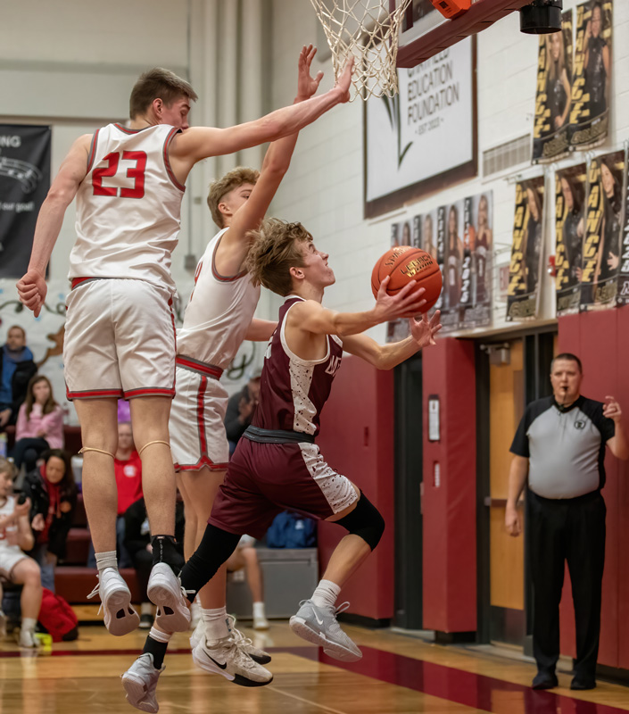 Chatfield’s Aiden Johnsrud flips in the very difficult shot around the arms of Houston’s Alex Wedl (#23) and Morgan Rohweder. The Gophers overcame Houston late for 64-57 win. Photo by Leif Erickson