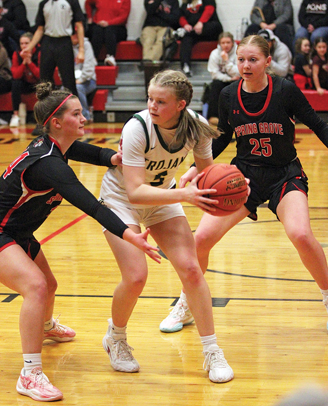 Rushford-Peterson’s Nadia Happel gets double-teamed by Spring Grove defenders Izabel Kaufmann (#14) and Kinley Soiney (#25). In a key Section 1A contest, SG notched a big 56-53 win over the Trojans. Photo by Paul Trende