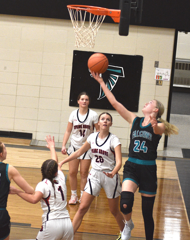 Fillmore Central’s Sophia Bronner goes for a tough reverse as Spring’s Grove’s Kylie Hammel (#20) and Izabel Kaufmann (#14) look on. SG beat FC 63-48, L/P 77-34, and La Crescent/Hokah 40-39 on a late Emerson Ingvalson shot to run their win streak to six. Photo by Lee Epps