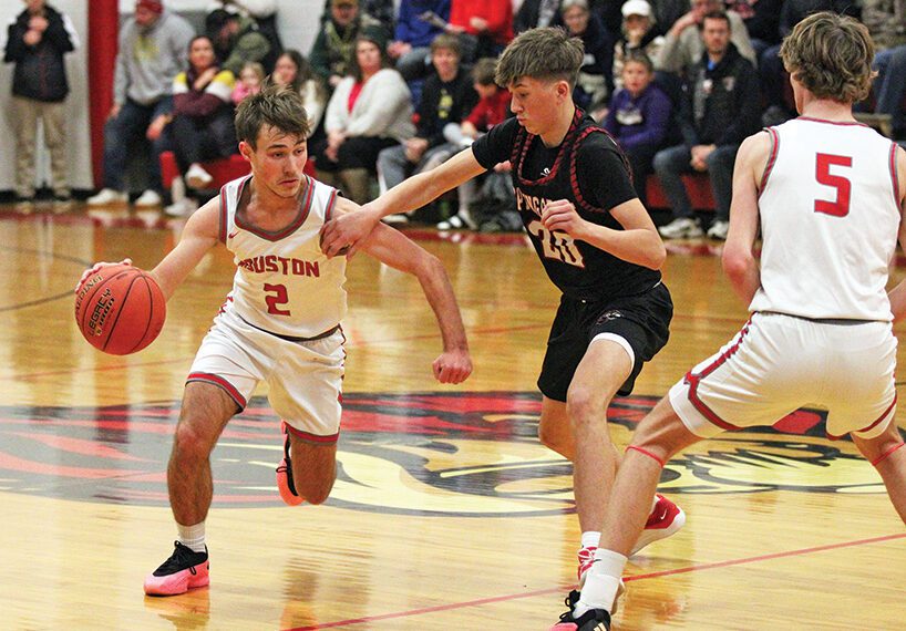 Spring Grove’s Lyric Stadtler (#20) tries to stay with Houston’s Zach Olson and the upcoming screen from Carter Geiwitz. The SEC-East leading Hurricanes (5-1, 7-2) topped the Lions 55-46 in overtime to sweep the season series. Photo by Paul Trende