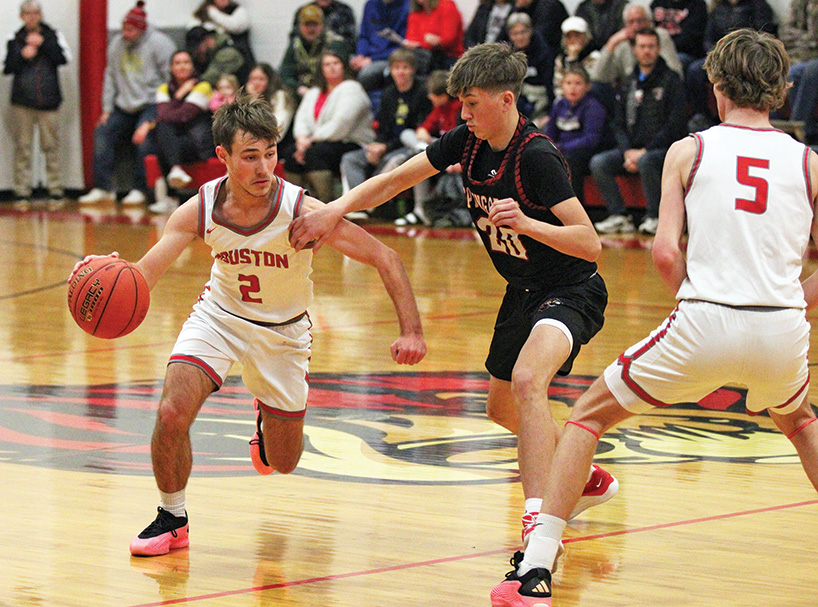 Spring Grove’s Lyric Stadtler (#20) tries to stay with Houston’s Zach Olson and the upcoming screen from Carter Geiwitz. The SEC-East leading Hurricanes (5-1, 7-2) topped the Lions 55-46 in overtime to sweep the season series. Photo by Paul Trende