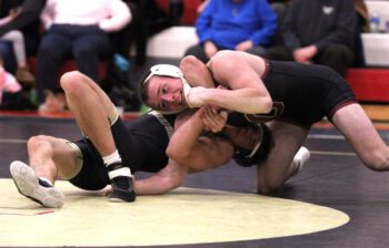 Caledonia/Houston’s Braxton Lange goes for the late alligator-like-roll to try to get points on Chatfield’s Hunter Polikowsky. But the Gopher beat the Warrior by 4-1 decision as part of the #1 in Clas AA Gophers’ 62-0 dual win. Photo by Paul Trende