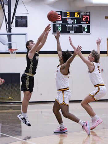 Caledonia’s Mason King launches a three over Stewartville defenders Abdimalik Abdi and Jayce Klug. The #2 in AA Warriors fell to the #9 in AAA Tigers, 76-71. King notably scored his 1,000th career point two games prior versus St. Charles. Photo by Paul Trende