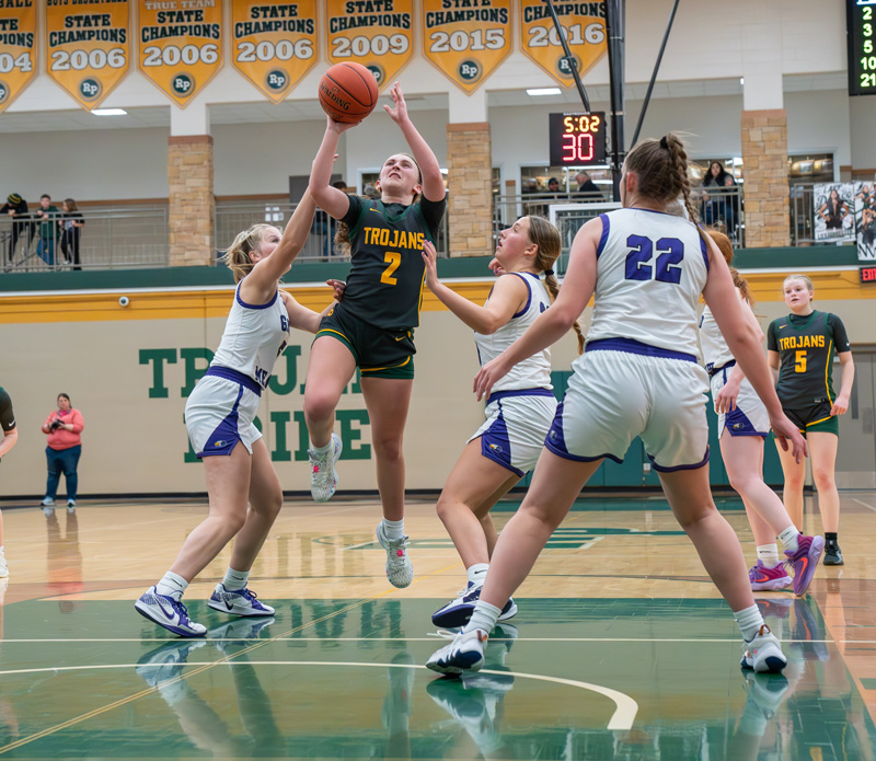 Rushford-Peterson’s Torryn Schneider goes down main street past GM defenders Aspen Kolling (left) and Naomi Warmka (right) while Rylee Schaufler (#22) is in the foreground. But the Larks used peripheral shooting, nine made threes that is, to top R-P 52-46 in a key 1A matchup. GM improved to 14-2. Photo by Dawn Hauge