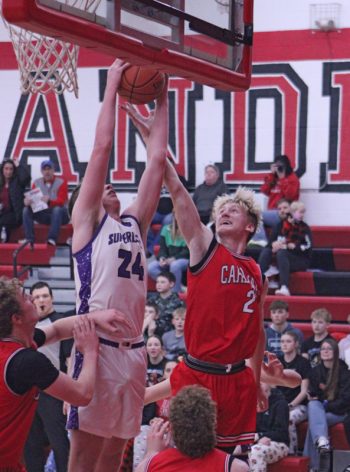 Grand Meadow’s Logan Grafe out-rebounds LeRoy-Ostrander’s Reid Hungerholt in the teams’ rivalry SEC matchup. But L-O posted a 70-49 win. The Larks were one game removed from ending a 31-game losing streak via a win over Lyle/Pacelli. Photo by Paul Trende