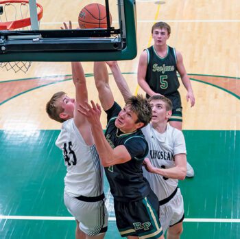 Rushford-Peterson’s Zach Baker has a lot of length to contend with in Kingsland’s Max Erdman (left) and Gavin Hubka (right), both 6’5”. R-P downed the Knights 74-52, as the #7 in Class A Trojans won their ninth in a row. Photo by Dawn Hauge