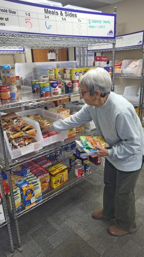 Volunteer Marlene Peterson stocks the shelves at the Preston Food Shelf. Photo by Hannah Wingert