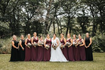 The bride and her attendants. From left to right Heidi Kinstler, Amy Hoscheit, Jessica Kohnen, Danielle Myhre, Kayla Sipley, Trisha Dehning, Chelsey Hoscheit, Kayla Klug, Cady Brant, Heather Ideker, Mariah Fretty and Amanda Meyer. Photo by Sydnie and Me Photography