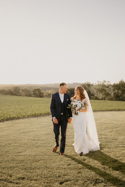 Newlyweds Morgan Malley and Quinn Frisell share a joyful moment at their wedding on June 8, 2024 at Serenity Hills. Photo by Grace Sveen Photography