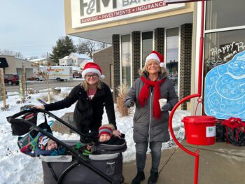 Olivia and Cameron watch as Pam Mensink and Megan Persons having fun ringing bells to help those in need. Photo submitted