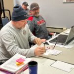 Retiring Fire Chief Chad Rasmussen, left, and the new fire chief, Nick Smith report to the council. Dave Lombard from Public Works is in the background. Photo by Wanda Hanson