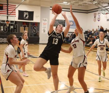 Kingsland’s Vaira Merkel takes the interior shot over Spring Grove’s Brinley Middendorf while Emerson Ingvalson (left) is also pictured. The Lions won their 10th straight game in beating the Knights 58-26. Photo by Christine Vreeman