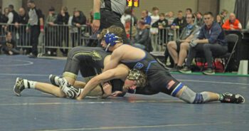 Caledonia/Houston’s Braxton Lange tries for more than just a leg versus Kasson-Mantorville’s Aiden Friedrich in the 1AA 133-pound finals. Lange (20-3) fell by 7-0 decision, but earned a trip to state, his third total, courtesy of a section runner-up finish. Photo by Paul Trende
