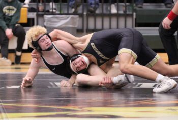 Caledonia/Houston’s Max Schmitz tries to cinch up a cradle of sorts on LARP’s Nolah Happel. Schmitz won a 15-1 major decision in the match, part of the Warriors sweeping the triangular with the Screamin’ Eagles and Dover-Eyota. Photo by Paul Trende