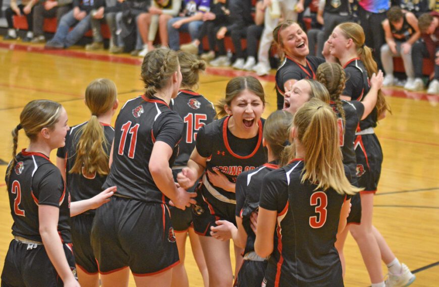 Spring Grove/Mabel-Canton’s girls celebrate at 60-45 win over Southland in their regular season finale, which clinched the Lions there second straight SEC crown (a share with Grand Meadow). Coach Taylor Elton’s Lions (21-5) are 1A’s 2-seed. Photo by Lee Epps