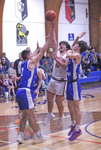 Houston’s Maddox Rodriguez tosses up a lane shot surrounded by Mabel-Canton’s Tyler Larson (left) and Isaac Underbakke (right). M-C knocked off the East leading Hurricanes in the (non-conference) game 61-58, but Houston beat Lanesboro 58-51 to secure a share of the SEC-East title. Photo by Paul Trende