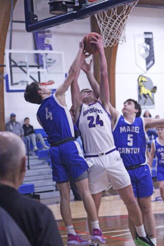 Grand Meadow’s Logan Grafe contends with Mabel-Canton’s Isaac Underbakke (left) and Cael Wangsness for a rebound. M-C posted a 57-49 win in the game. Photo by Paul Trende