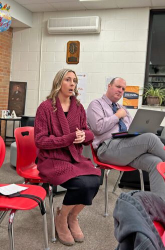 Principal Alexa Michaels presents her mid-year report on site goals at the high school while Michael Mangan listens. Photo by Wanda Hanson