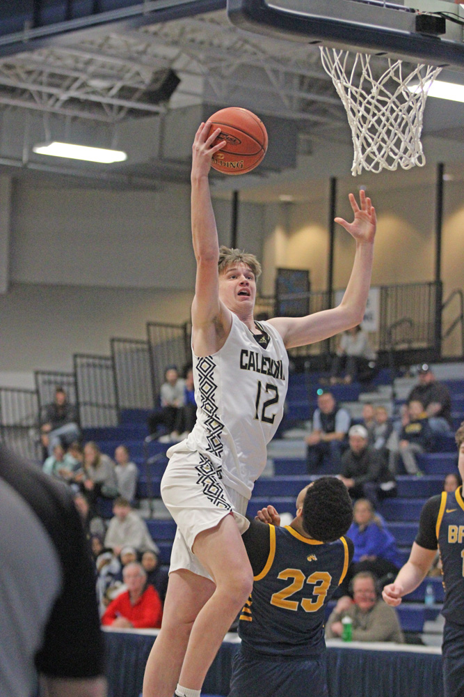 Caledonia’s Reid Klug goes down main street in the Warriors third place game with The Breck School. After trailing 56-35 at intermission, the Warriors came back to tie the Mustangs (including 73-73 via a Klug dunk), but they eventually fell 98-77. Photo by Sara Kroshus