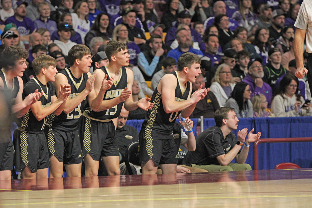 Caledonia’s bench (most visible Zeke Gengler, Coby Hammell, Noah Treptow, Ben Stemper and Assistant Coach Noah Kearney) cheers on their troops in Caledonia’s state semifinal contest at Williams Arena with Albany. Photo by Paul Trende