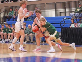 Kingsland’s Parker Johnson and Rushford-Peterson’s Will LaFleur battle for a loose ball late in the teams’ section quarterfinal while Knight Zach Reiland is also pictured. In a scrap, the Trojans pulled away late to down Kingsland 70-54. Photo by Paul Trende