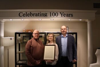 First State Bank of Fountain President Chuck Johnson stands next Michelle Redalen and Mike Drury displaying a loan agreement from 1925 for $500 between Chuck’s grandfather Hiram Johnson and Mike and Michelle’s grandfather Reuben Drury. This was the investment Drury’s Furniture needed to get off the ground. Photo by Jason Sethre