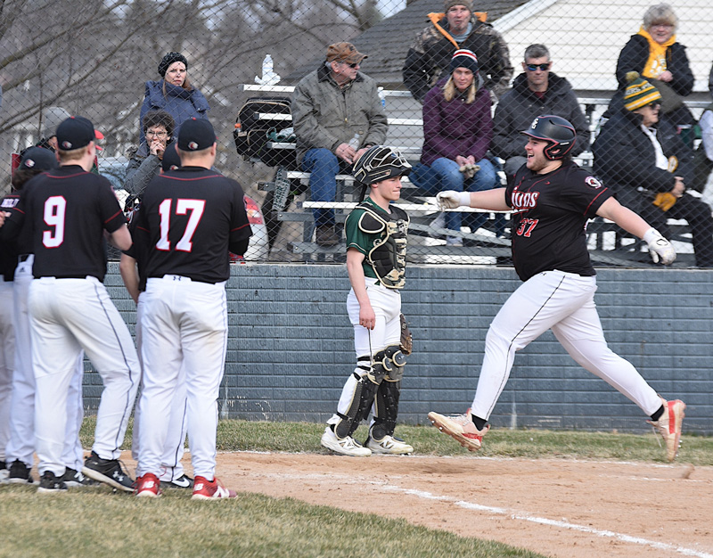 While Rushford-Peterson catcher Owen Lange averts his eyes, Spring Grove’s Tysen Moen approaches a home-team, home-plate celebration. Moen erased a two run Trojan lead with a three-run home run, creating the final 5-4 score a half-inning before the end. Photo by Lee Epps
