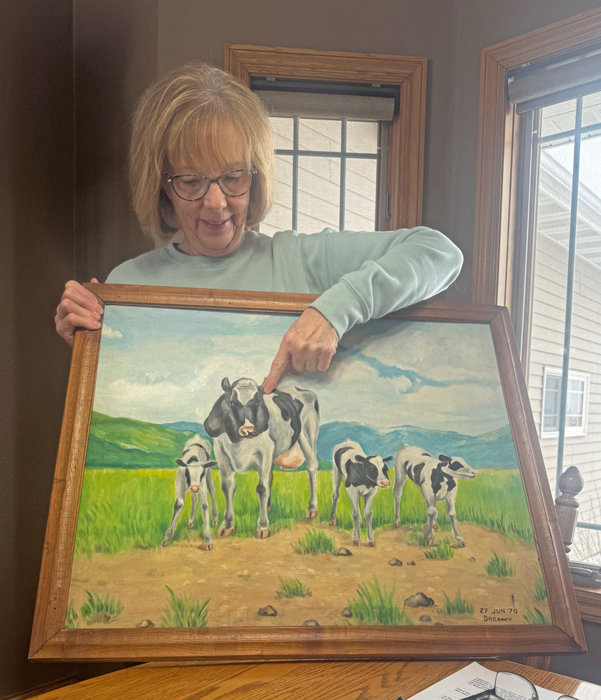 Sharon Wissing shows off the treasured painting of part of the family’s dairy herd. Photo by Charlene Corson Selbee