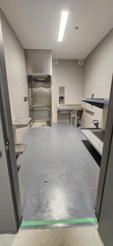 A view of a new, handicap accessible jail cell. The table has one seat installed and one open area for a wheelchair. Also note the roll-in shower with flip-down seat and easy access to the sink. Photo by Ellen Whalen