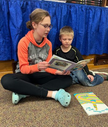 Eighth grader Elsa E. reads to kindergartner John A. Photo submitted