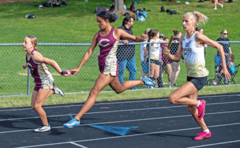 Amidst the 4x200, Chatfield’s Adeline Schild (left) and Savannah Peterson (right) exchange the baton next to Caledonia/Spring Grove’s Sienna Augedahl. The Warrior team took second in the race, Chatfield third at the Gophers’ home track and field meet. Photo by Leif Erickson