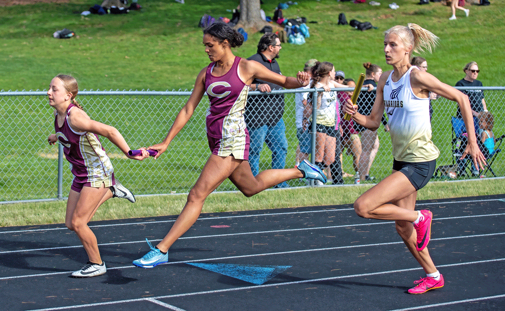 Amidst the 4x200, Chatfield’s Adeline Schild (left) and Savannah Peterson (right) exchange the baton next to Caledonia/Spring Grove’s Sienna Augedahl. The Warrior team took second in the race, Chatfield third at the Gophers’ home track and field meet. Photo by Leif Erickson
