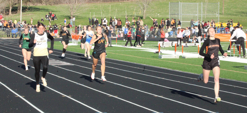 Caledonia/Spring Grove’s Nicole Banse and LFCMC’s Lillyan Kiehne finish a distance second and third to St. Charles’ Madilynn Bjerke in the 400-meters at the Saints’ home track and field meet. Photo by Paul Trende